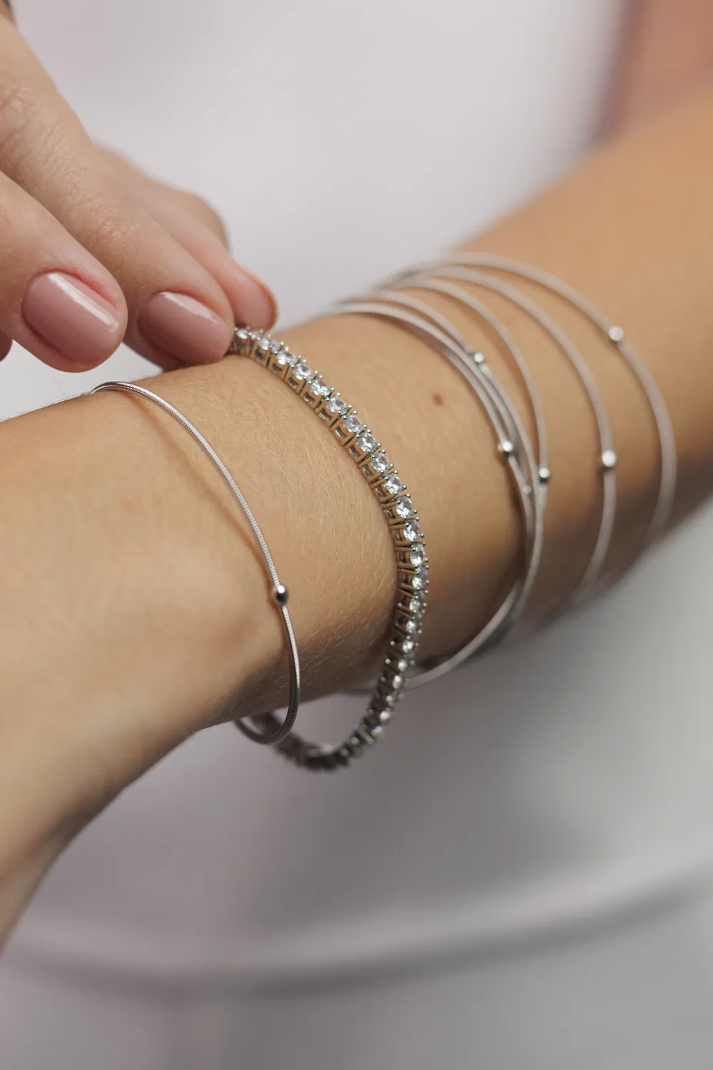 Braceletes e pulseiras finas no pulso
