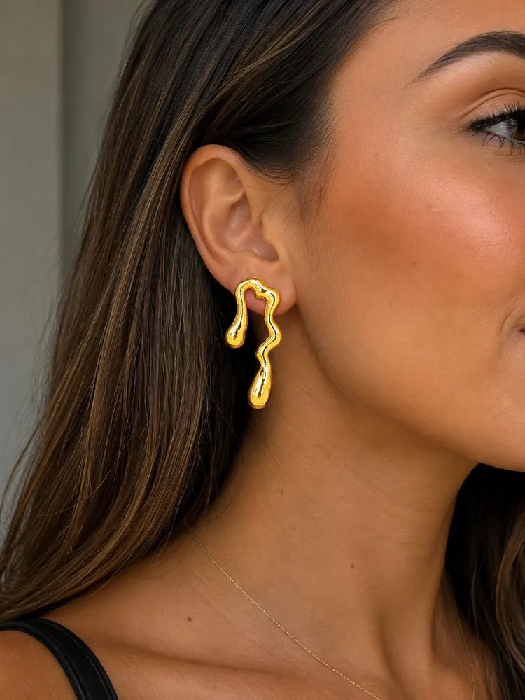 Brinco dourado de design orgânico na orelha